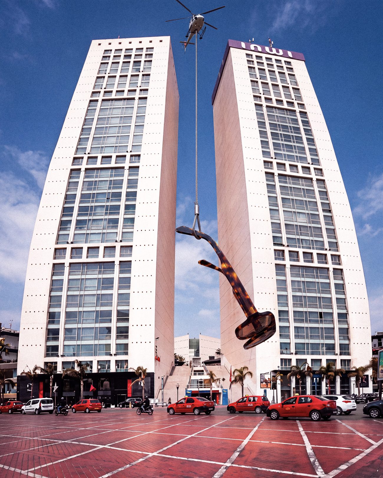 Monture géante suspendue à un hélicoptère entre les tours du Twin Center