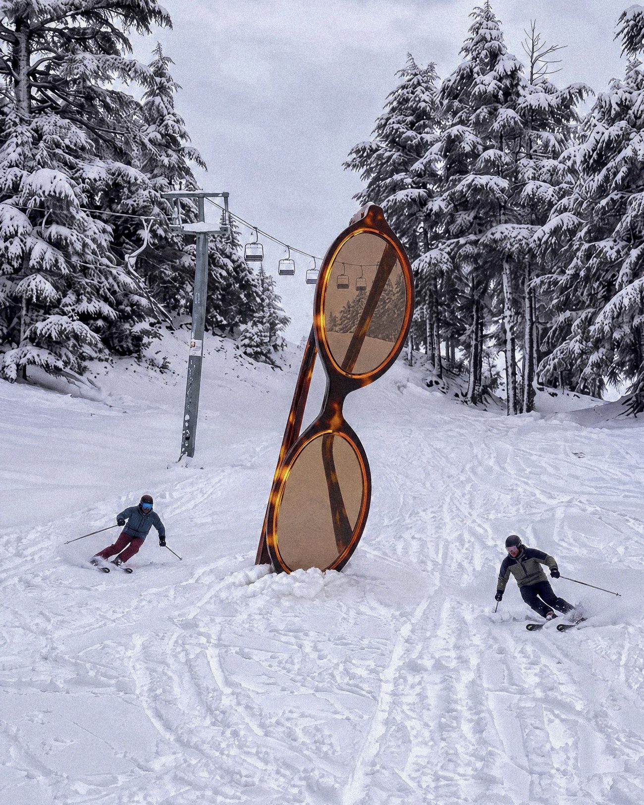 Monture géante plantée dans la neige d'Ifrane, deux skieurs autour