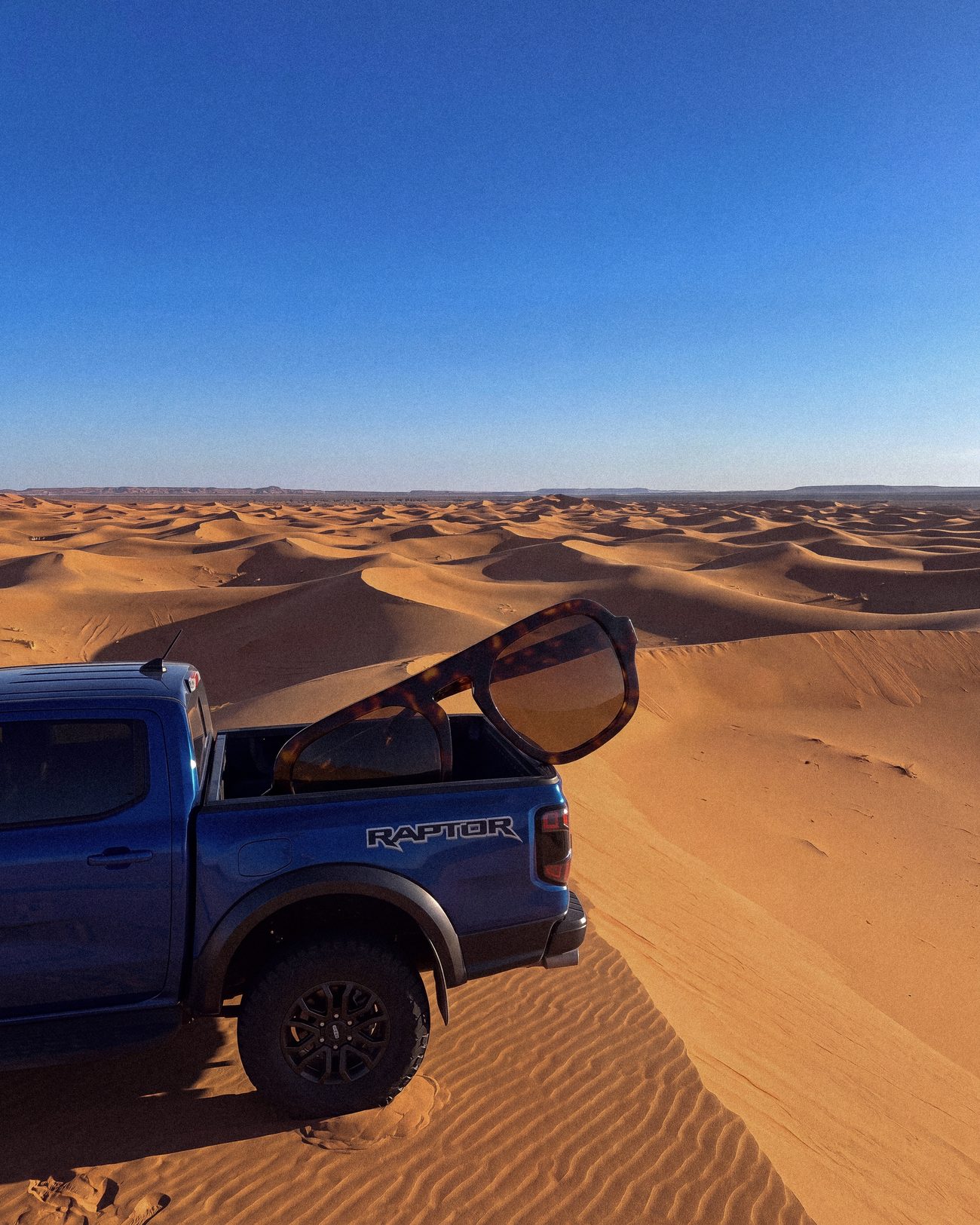 Monture géante à l'arrière d'un pick-up dans les dunes de Merzouga